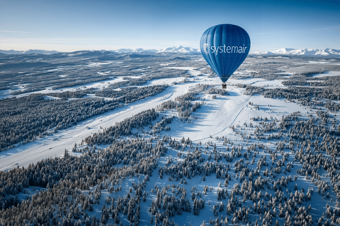 En luftballong svävar över en frodig, grön skog med en flod nedanför, mot en solnedgångshimmel i bakgrunden.