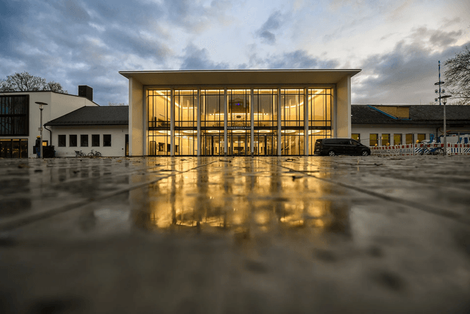 Entrepreneur with laptop walking next to business partner and discussing startup in office lounge with high tech interior